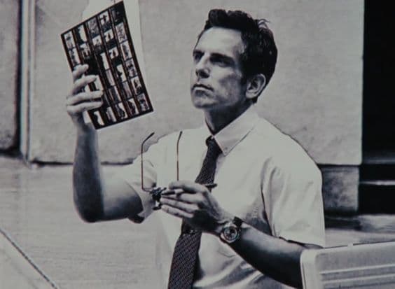 This may contain: a man holding up a book in his hand